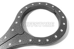 A close-up of the Heavy Aluminum Cangue with Padlock Bondage Yoke Shrews Fiddle Restraint by The Cuffstore shows its textured aluminum design with evenly spaced rivets, partially open on a white background, with CUFFSTORE faintly overlaid.