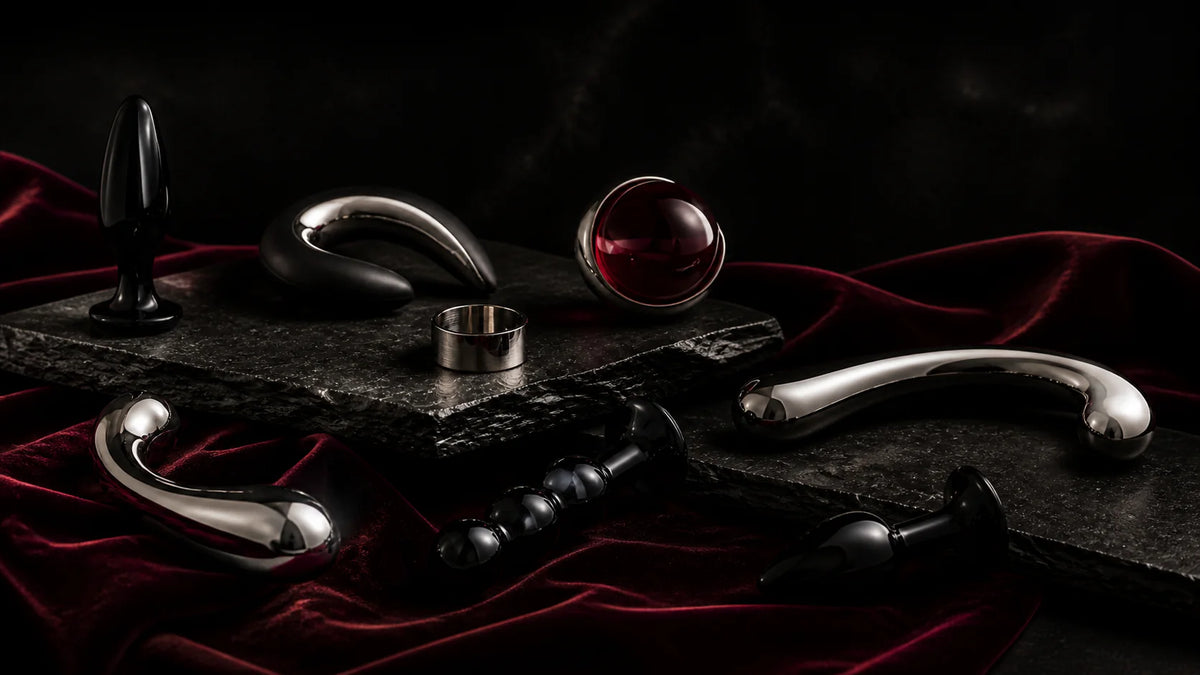 Polished chrome curves, black sculptural forms, and a metal ring on oxblood velvet.