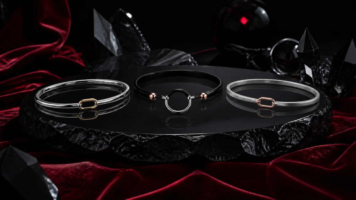 Polished, satin, black, and rose-gold anklet forms on dark stone.