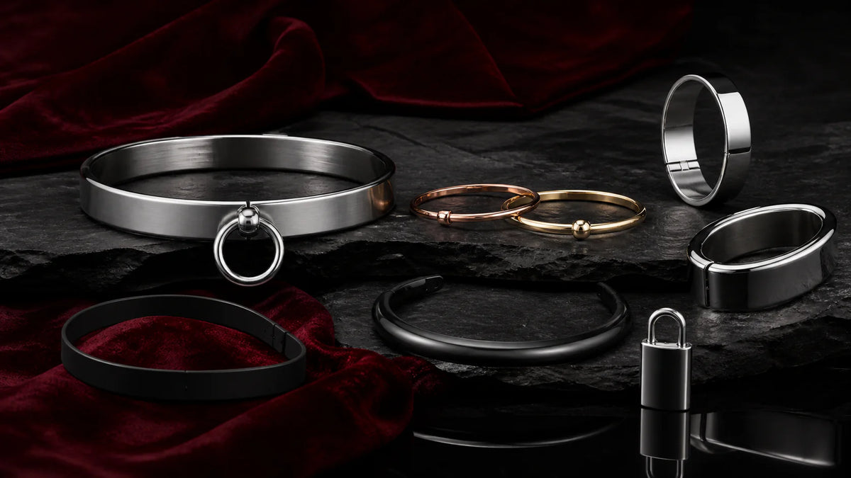 Metal collar arcs, elliptical cuffs, bracelets, and a small padlock on velvet.