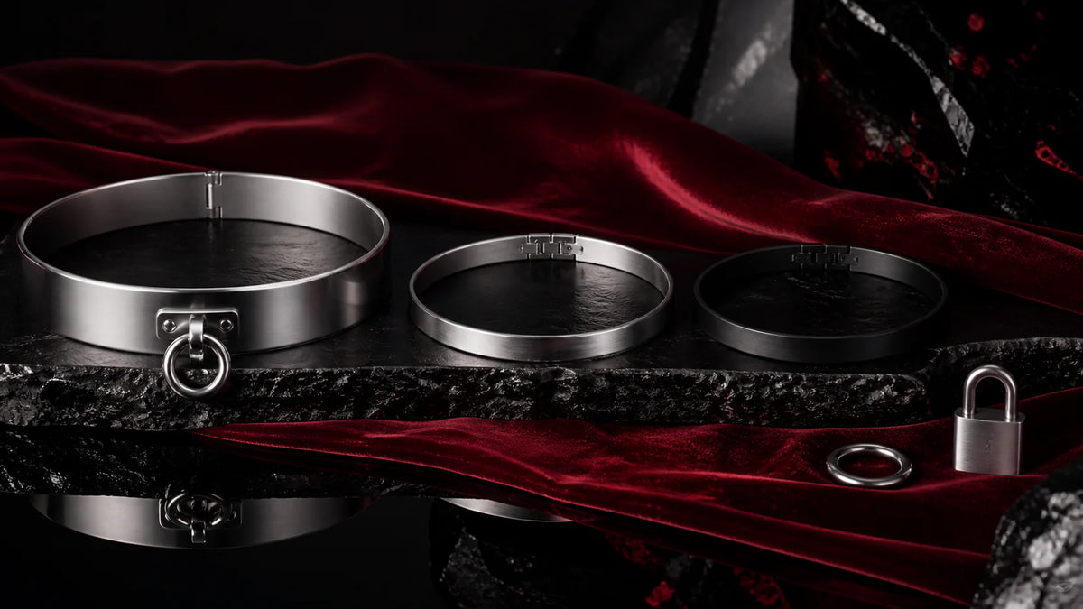 Polished, satin, and matte-black choker arcs with a small ring on dark stone.