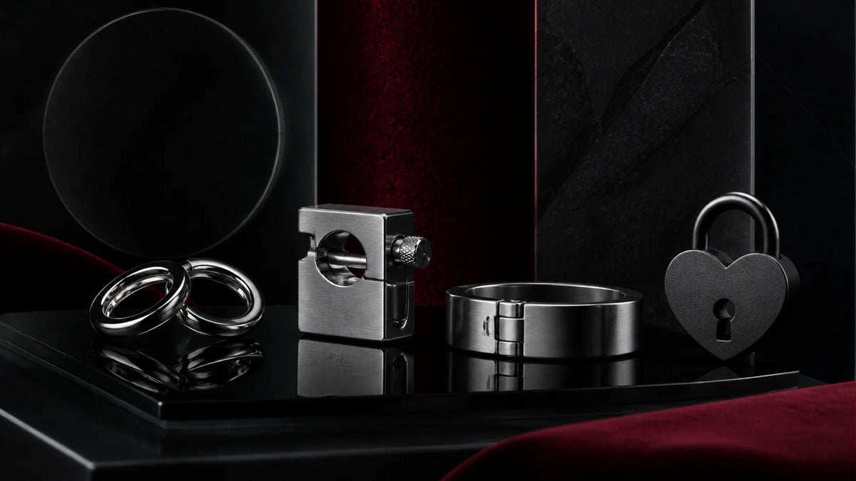 Polished weighted steel rings and clear acrylic hardware arranged on obsidian.